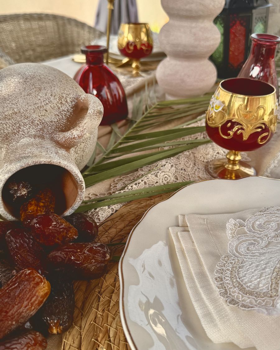 A Ramadan table with dates, a lantern and gold-rimmed glasses