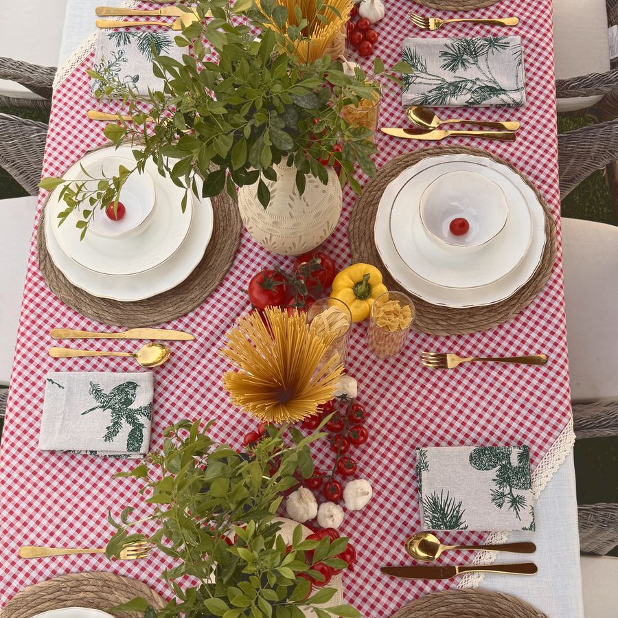 The same tomatoes and pasta styled down a gingham table with fresh greenery