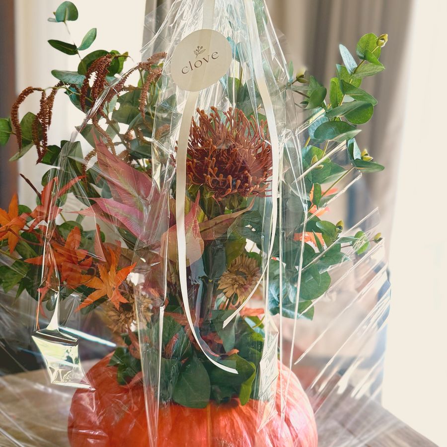 A floral pumpkin wrapped as a gift with a Clove tag